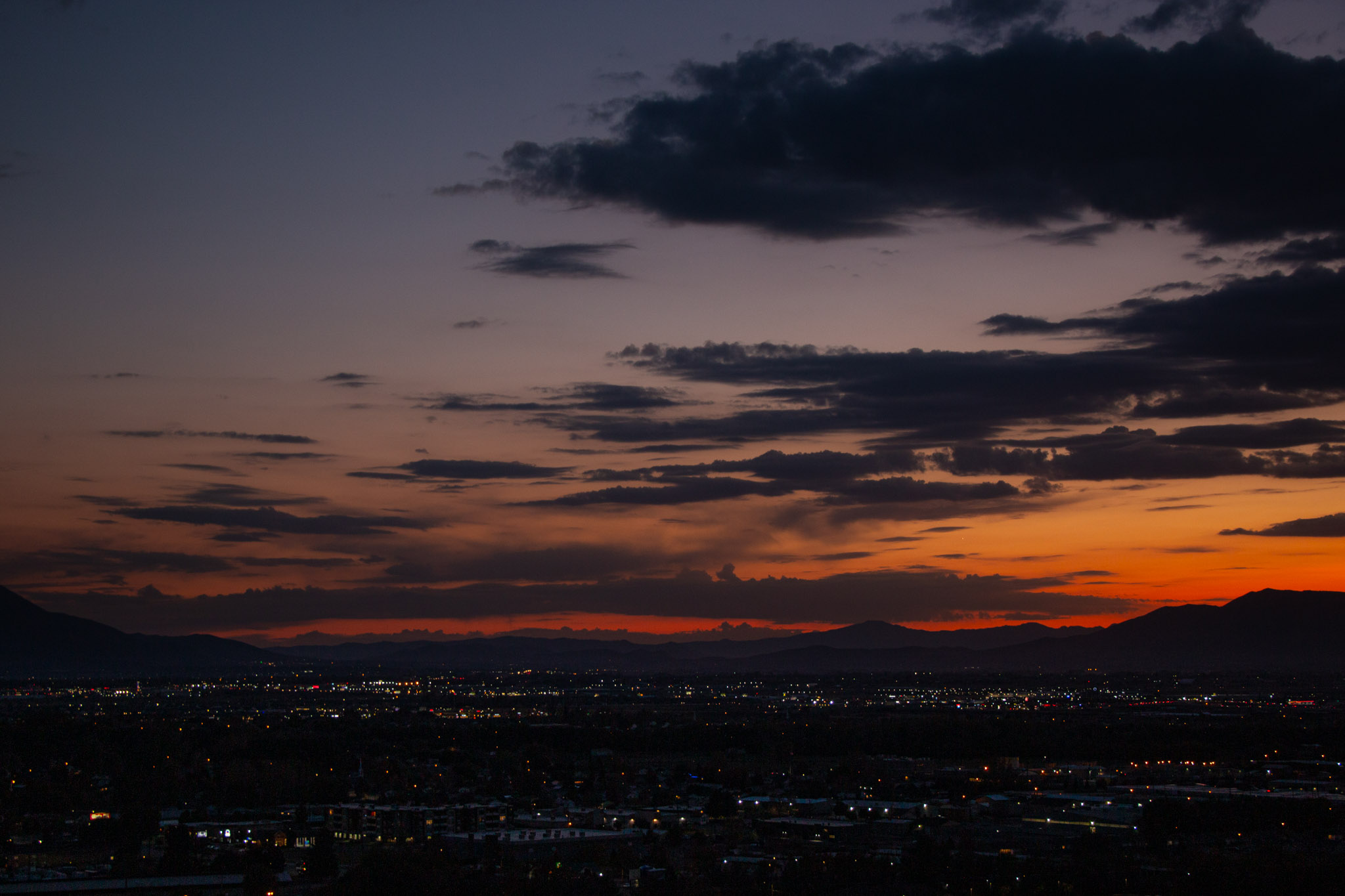 the horizon is still lit a little orange over city lights, dark grey clouds come in from the right